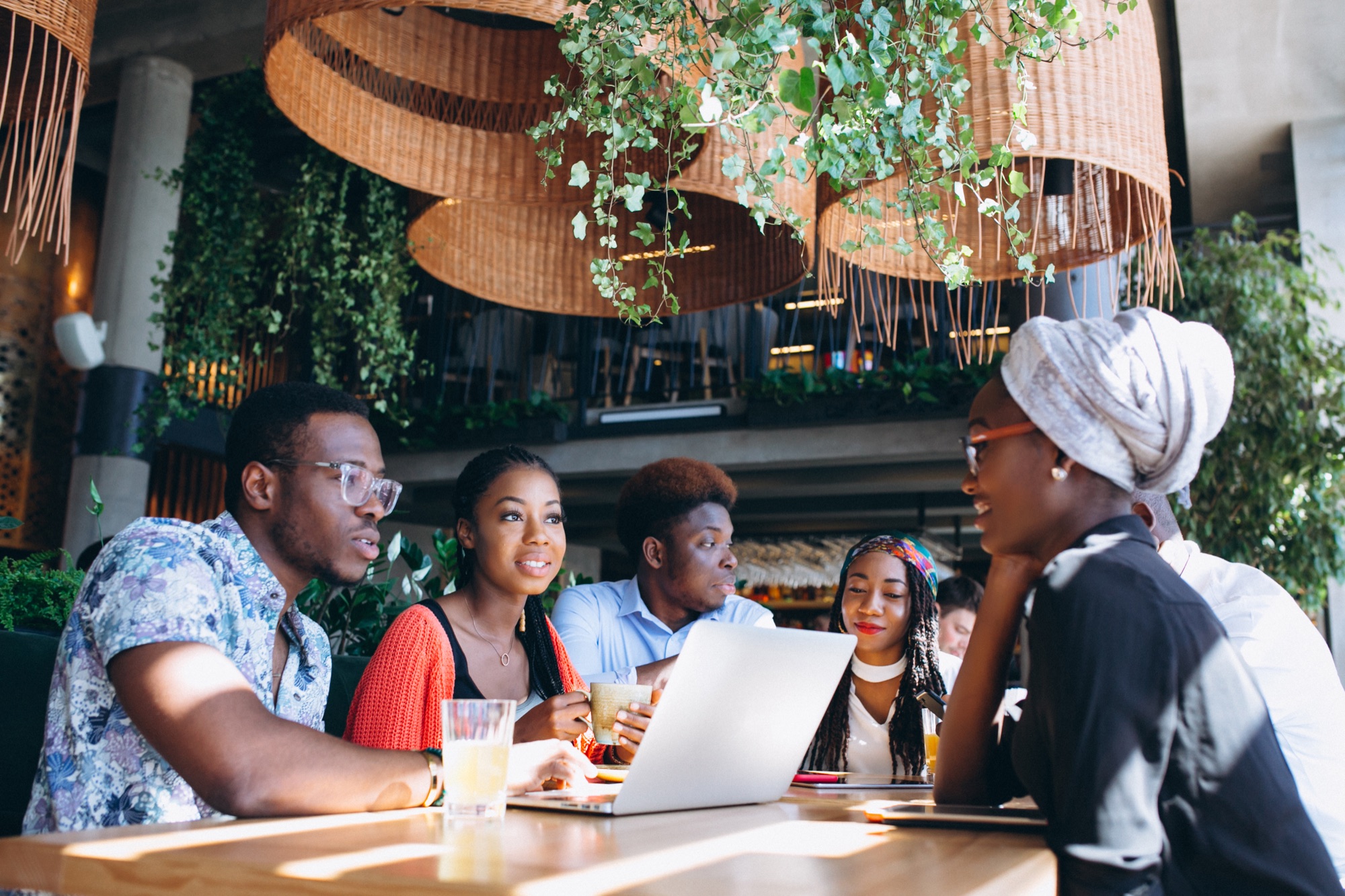 A group of professionals working together around a laptop